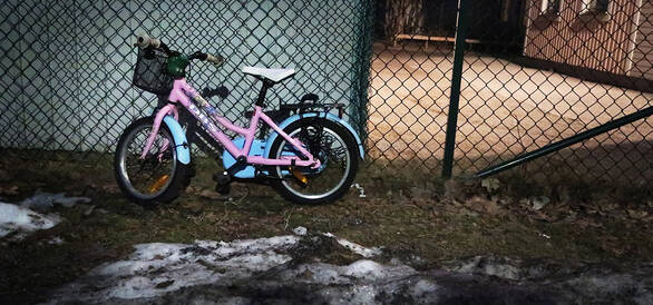 En ensam rosa cykel ute i vintermörker