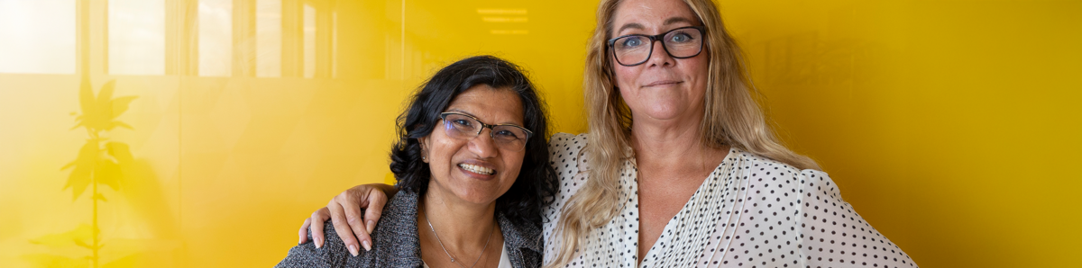 två kvinnor som ler