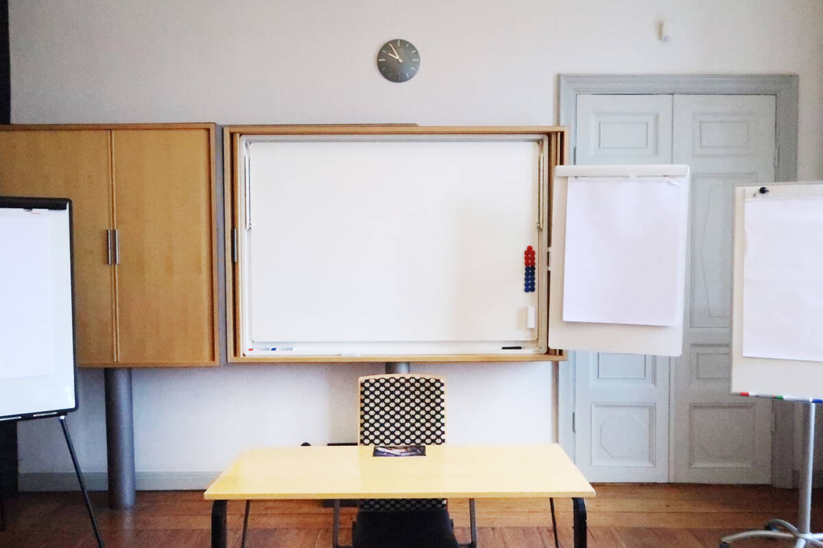 Föreläsningssal med kateder och whiteboard.