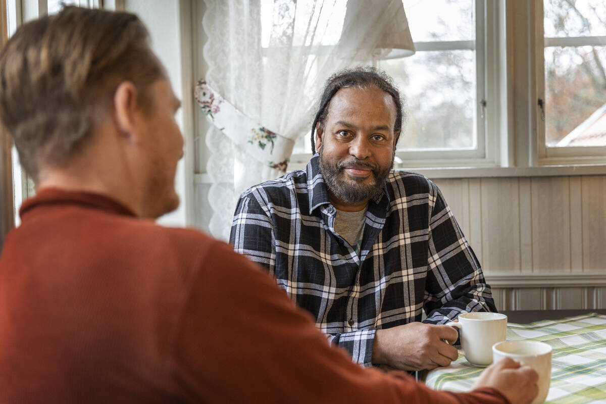 Två trevliga män sitter och fikar.