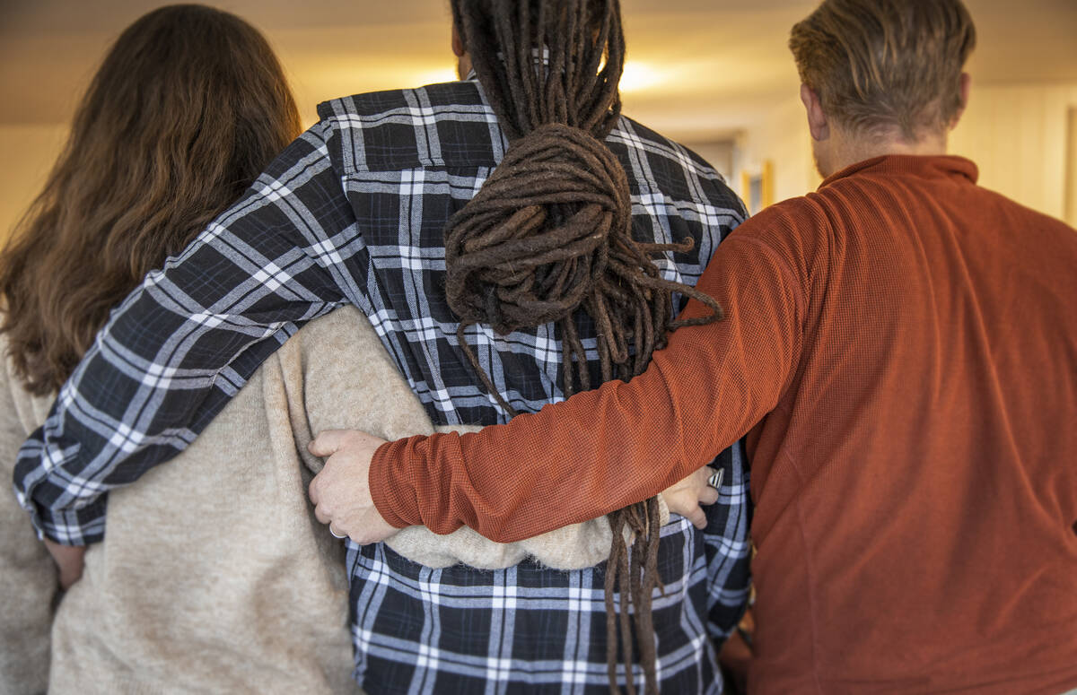 Tre kollegor håller varandra om ryggen.