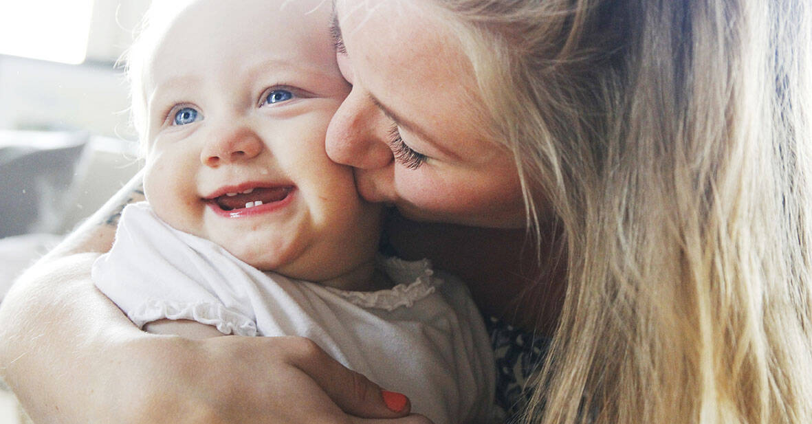 Ung mamma pussar sin bebis gosiga kind.