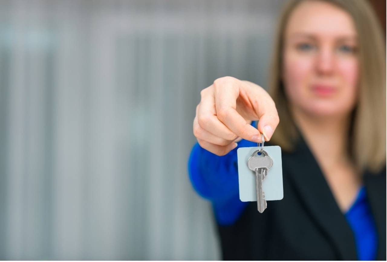 Kvinna håller fram en nyckel