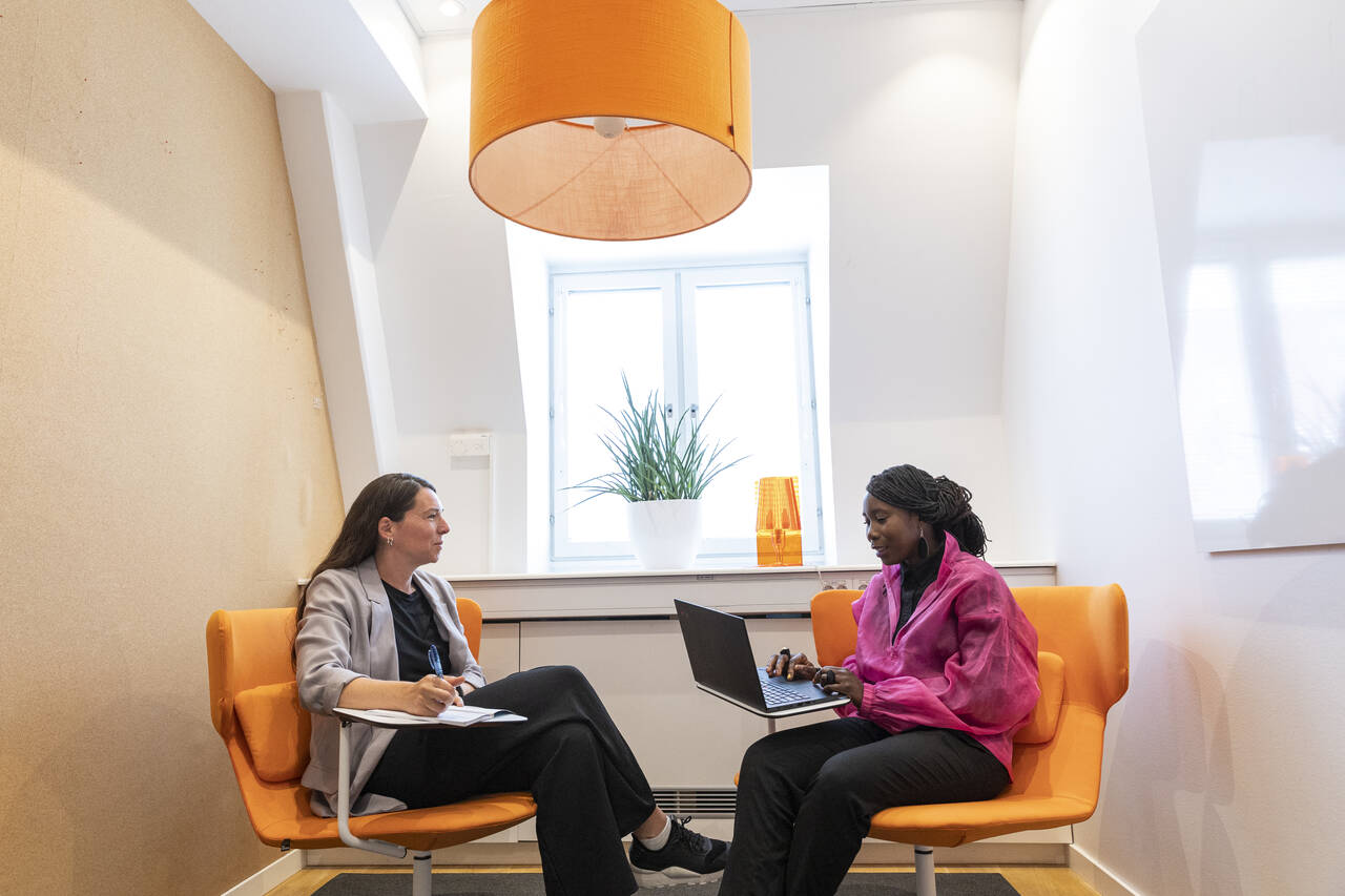 Två personer samtalar i ett mötesrum.