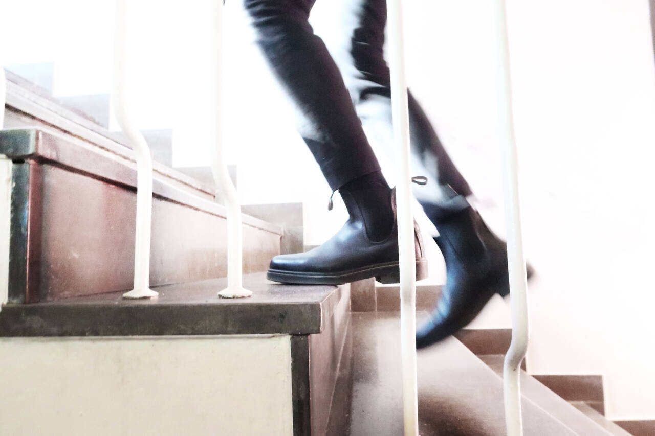 Fötter på väg upp för trappa.